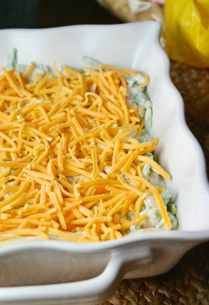 Green bean casserole topped with cheese before baking