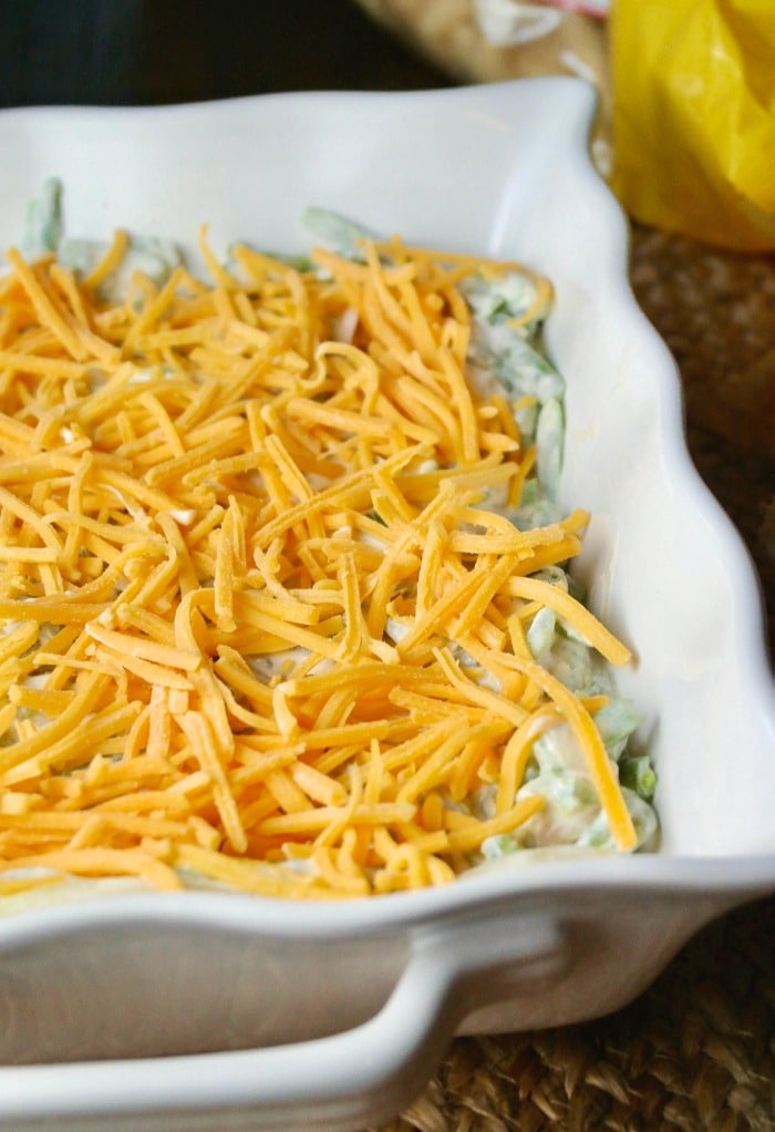 Green bean casserole topped with cheese before baking