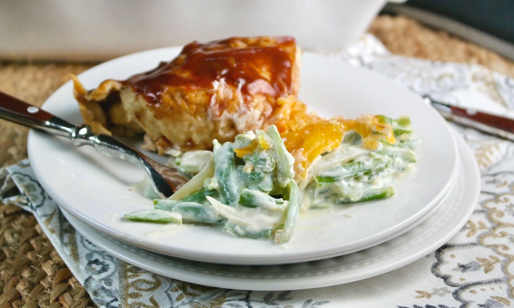 Keto green bean casserole on a white plate with baked chicken