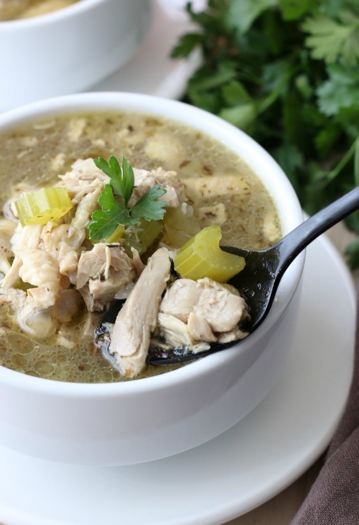 A spoon full of delicious chicken soup ready to be enjoyed.