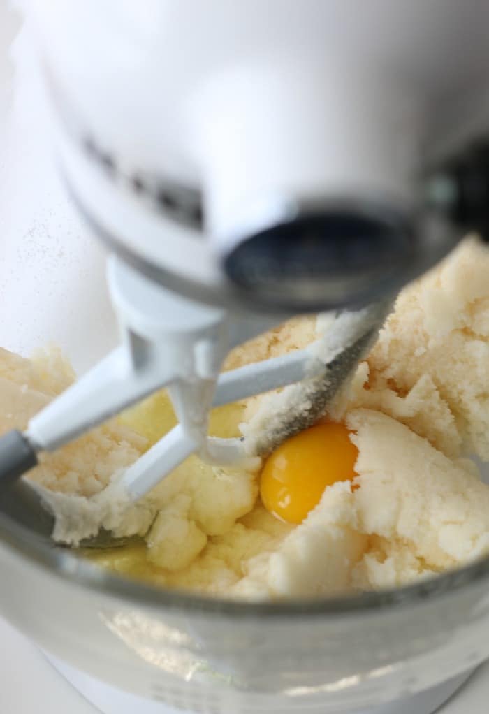 Here we see eggs being added to the batter for the Italian ricotta cookies. 