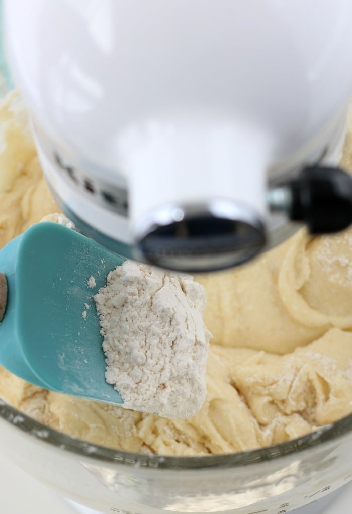 We slowly add in the dry ingredients for the glazed lemon cookies as the mixer runs to keep the batter smooth.