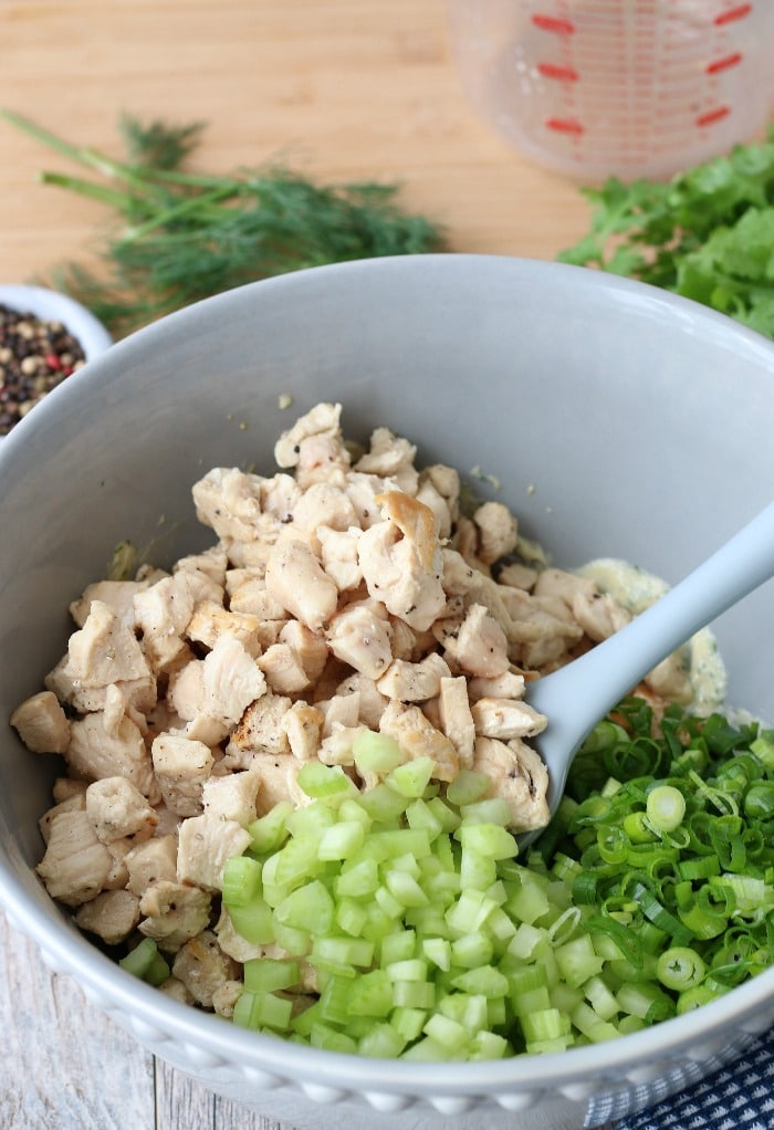 Making keto chicken salad is easy with this keto salad recipe. Here we see the chicken and vegetables being added to the dressing. 