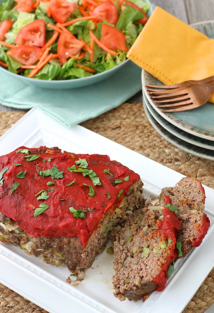 A top down view of the finished keto meatloaf recipe with salad in the background.