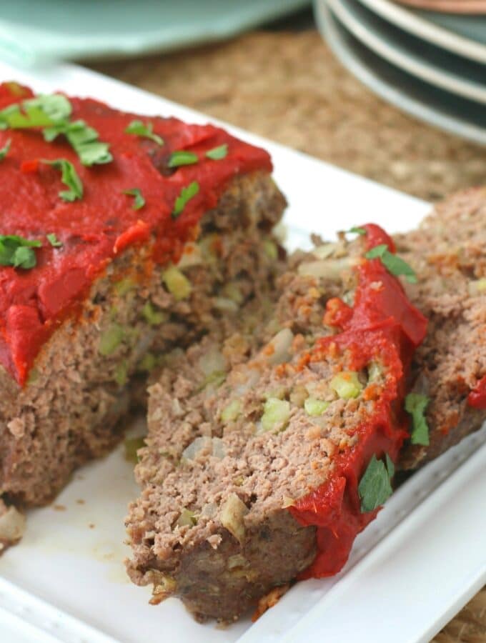 Sliced keto meatloaf on a white platter.