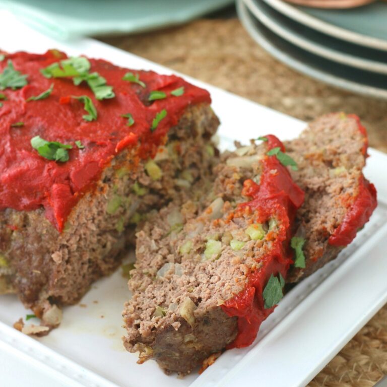 Sliced keto meatloaf on a white platter.