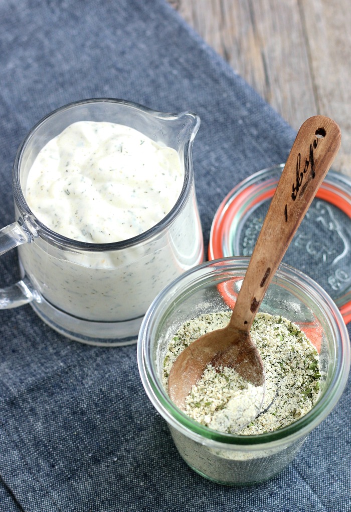 Here we see the glass container of homemade ranch dressing mix next the dry mix