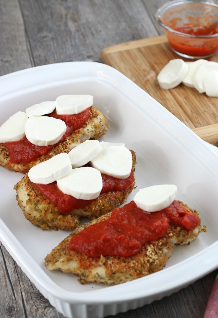 Now we see the low carb chicken parmesan being loaded up with some fresh mozzarella cheese before it goes into the oven.