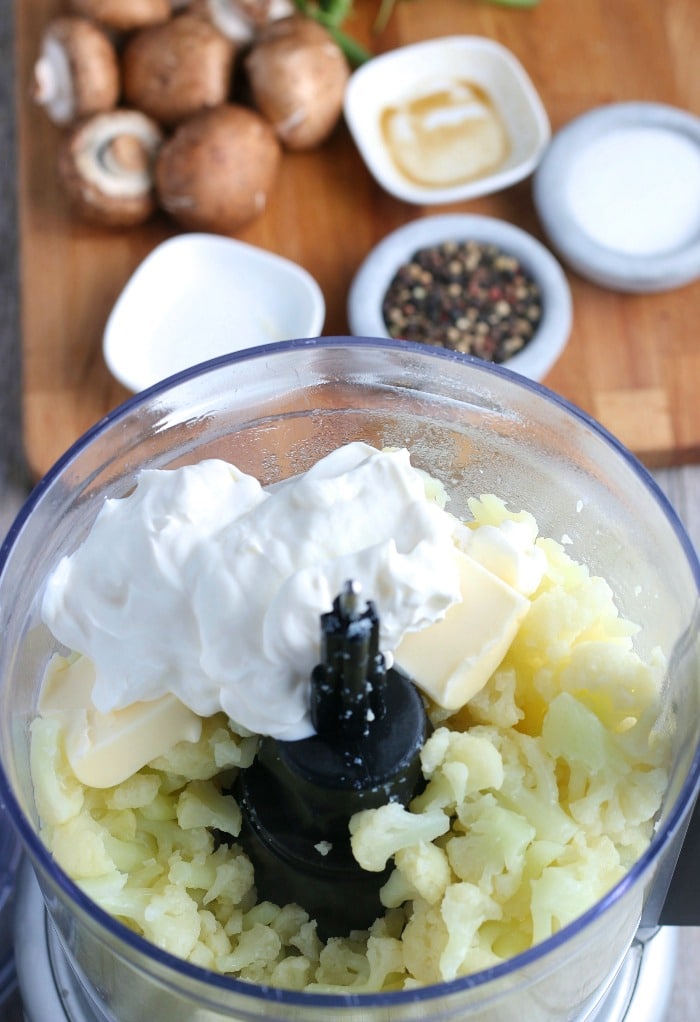 This image shows the food processor being filled with ingredients for the cauliflower shepherds pie mixture.