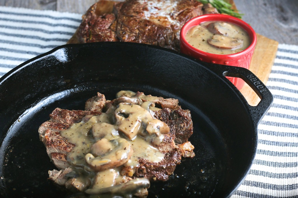 A horizontal shot of the finished pan seared steak topped with mushrooms!