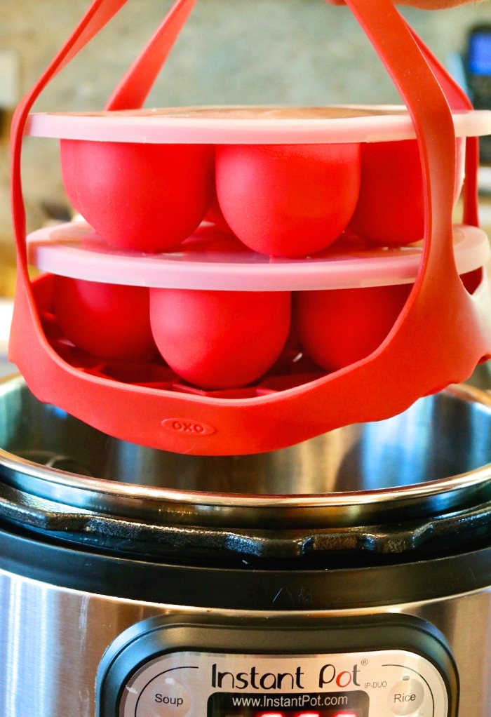 Silicone molds filled with ingredients for egg bits going into a pressure cooker