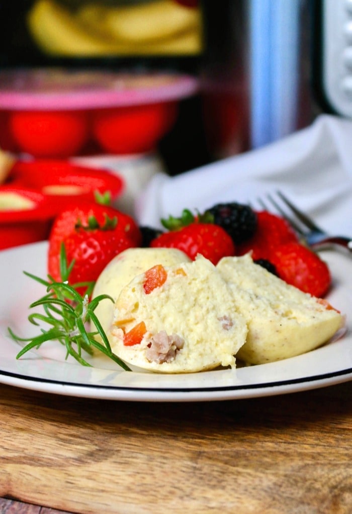 Cooked egg bites recipe on a white plate with fresh fruit