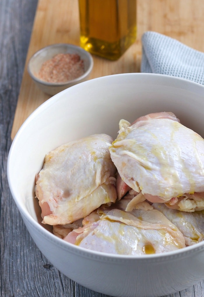 Here we see the keto chicken thighs drizzled with olive oil so the seasonings will stick.