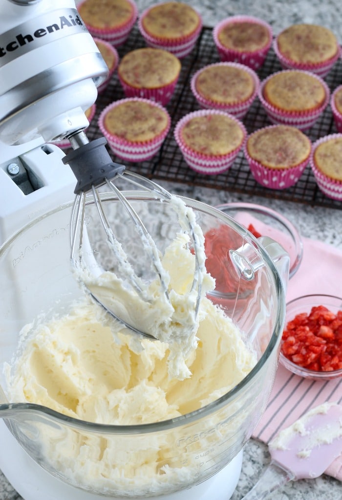 Buttercream strawberry frosting in a clear mixing bowl