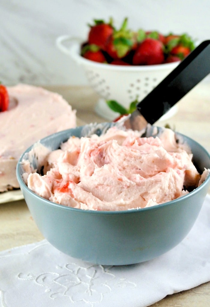 Homemade butter cream strawberry frosting in a gray-blue bowl