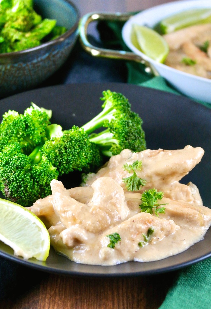 A black plate with coconut lime chicken and broccoli