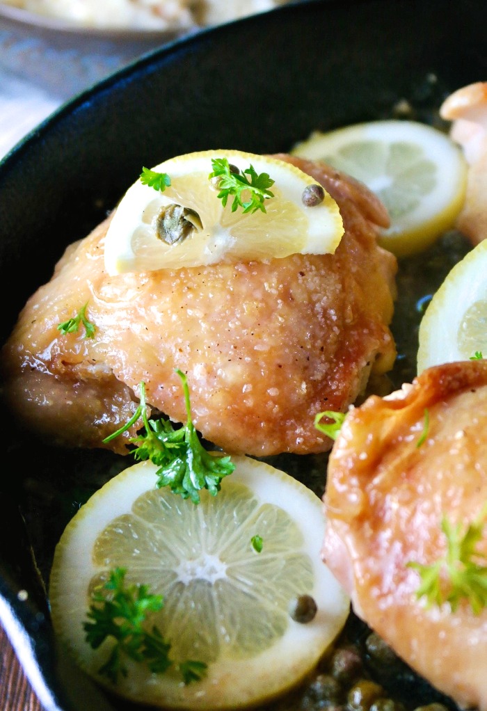 Easy skillet chicken piccata in a cast iron pan with slices of lemon