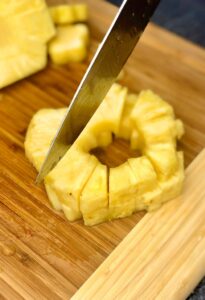 Cutting pineapple rings into chunks