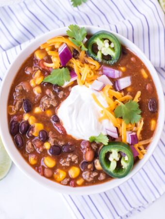 Soup topped with sour cream and sliced jalapeños