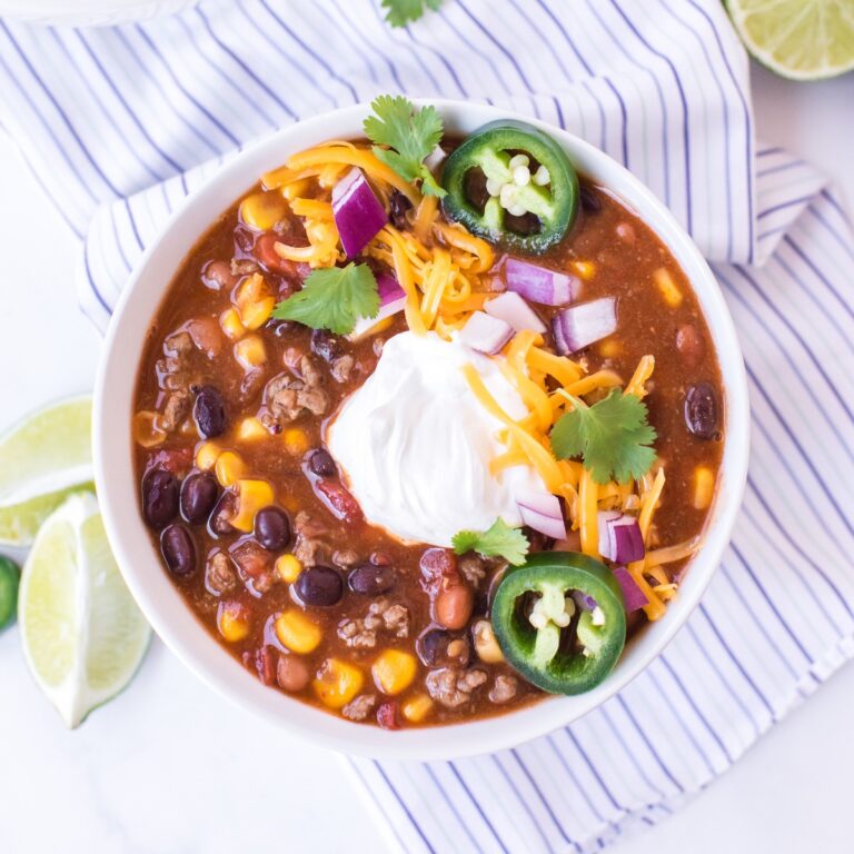 Soup topped with sour cream and sliced jalapeños