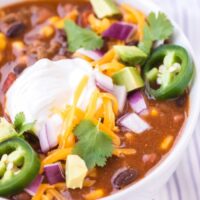 Close up shot of taco soup topped with sour cream