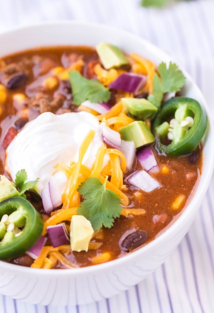 Close up shot of taco soup topped with sour cream