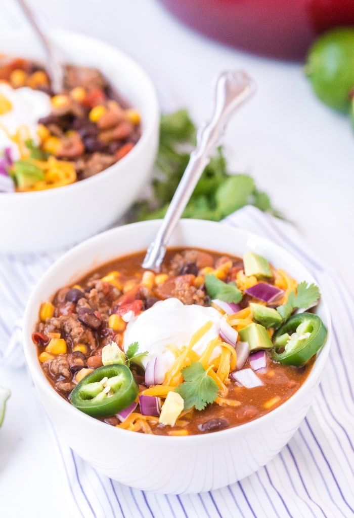 Tex Mex soup in a white bowl with a spoon in the bowl