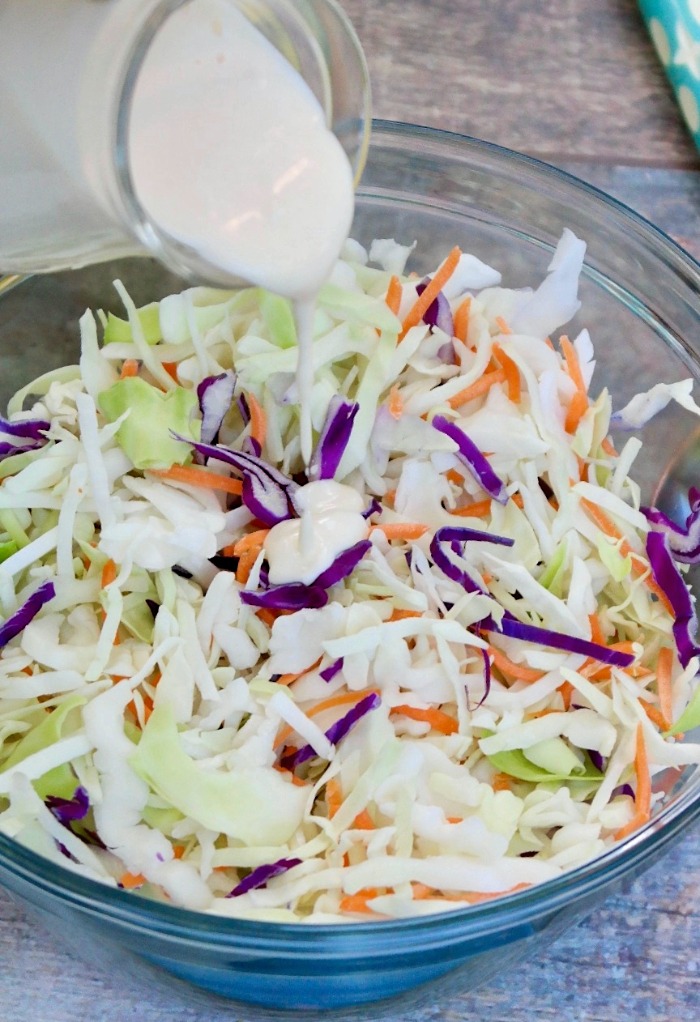 Pouring salad dressing over cabbage.