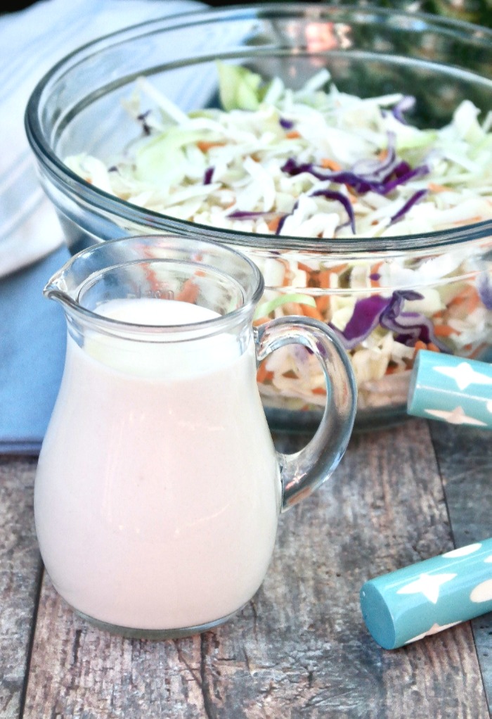 Simple sugar free coleslaw dressing in a small clear pouring decanter.