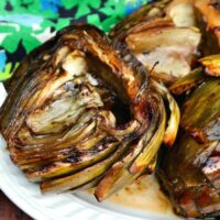 Cooked artichokes on a white platter