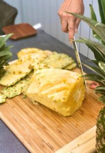 Photo of fresh pineapple cutting in V to remove the eyes