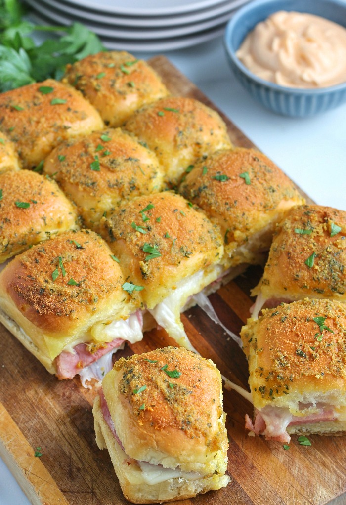 A look at the finished ham and cheese sliders on a cutting board ready to be separated and served. 