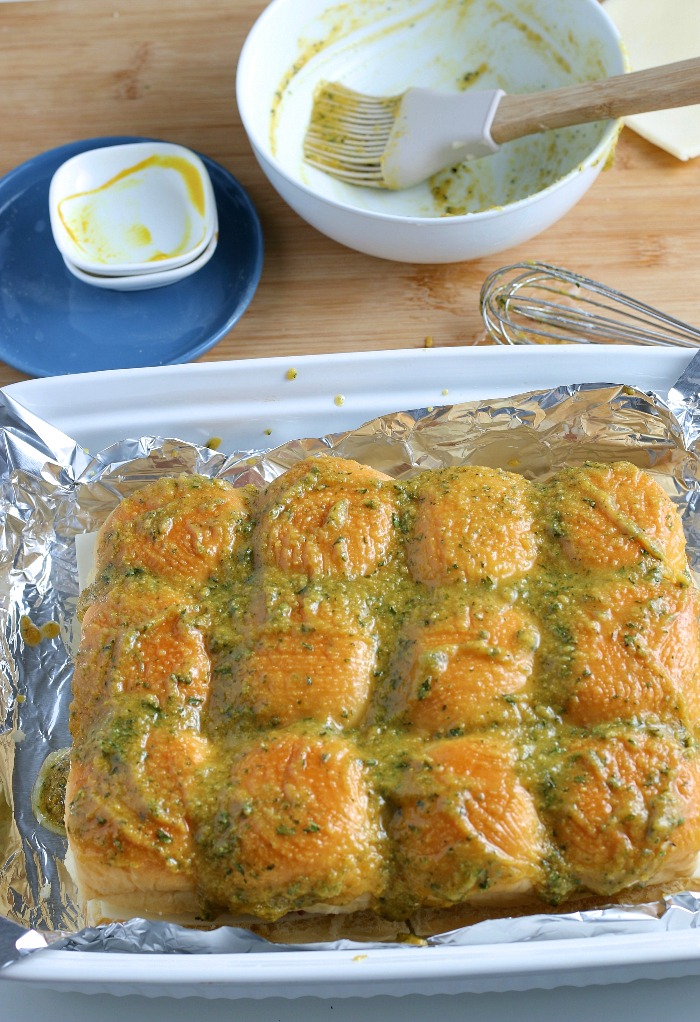 Finally we add the seasoned butter to the top of the buns so that they bake up nice and moist and flavorful.