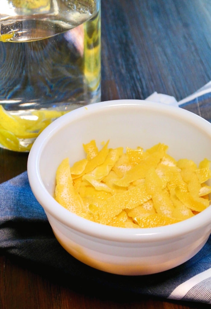 Fresh lemon peels in a white bowl to make homemade limoncello