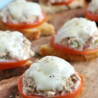 Bite size tuna melt open faced sandwich on a cutting board