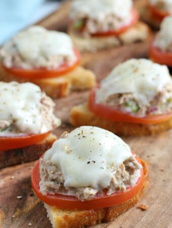 Bite size tuna melt open faced sandwich on a cutting board