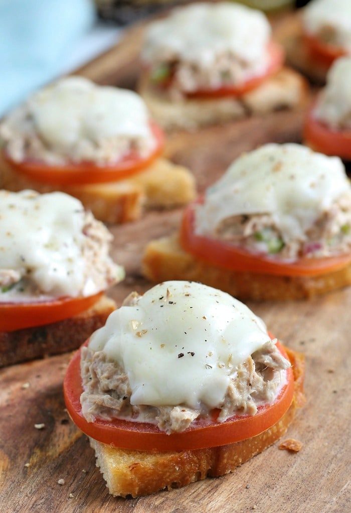 Bite size tuna melt open faced sandwich on a cutting board