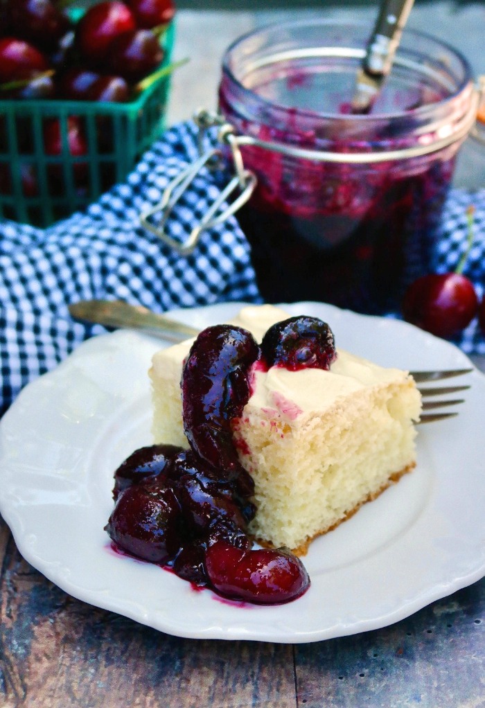 Slice of white cake topped with a homemade cherry topping.