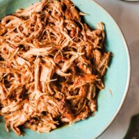 A blue plate with pulled pork ready to enjoy