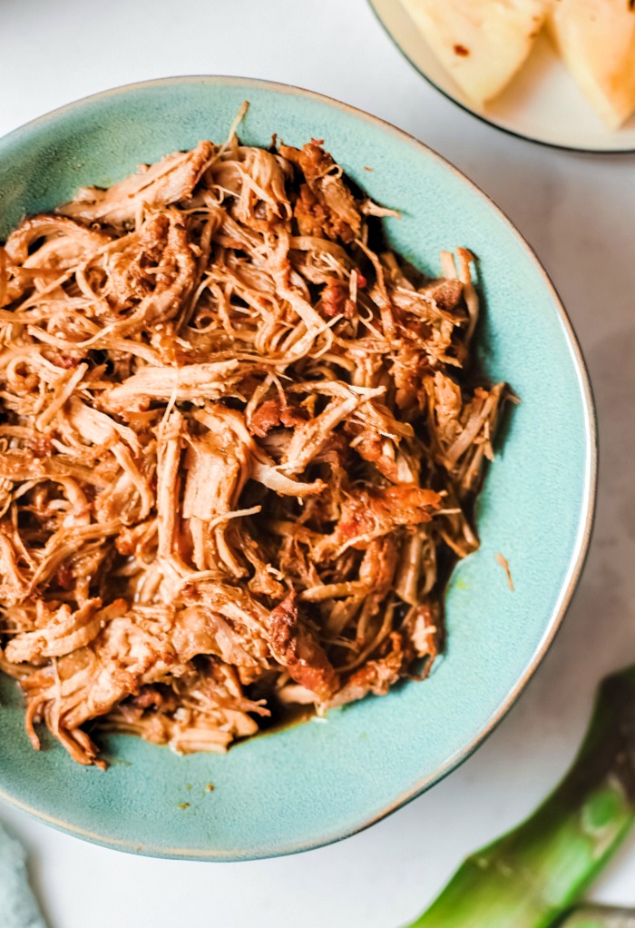 A blue plate with pulled pork ready to enjoy