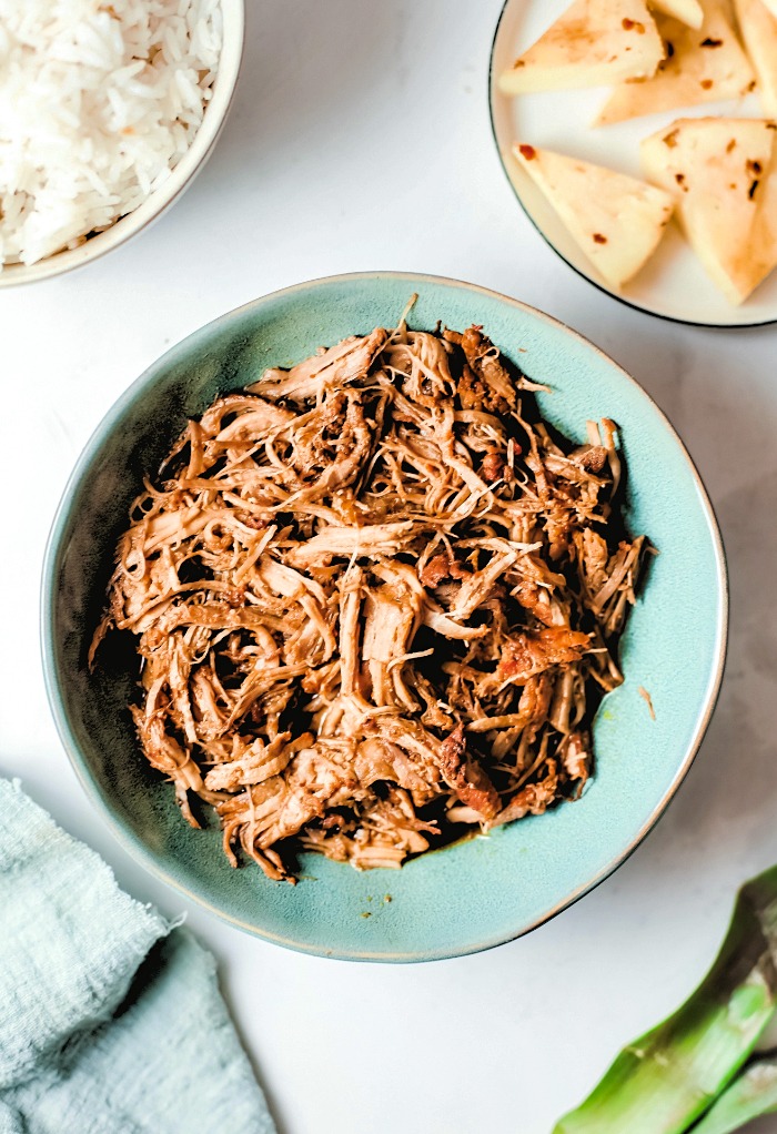 overhead shot of pulled pork with a side of rice and pineapple