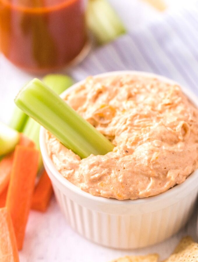 A white bowl with keto buffalo chicken dip with celery.