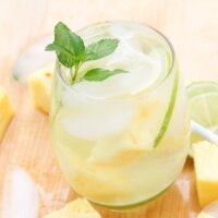 Pineapple mojito in a clear glass with a sprig of mint