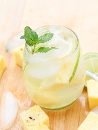 Pineapple mojito in a clear glass with a sprig of mint