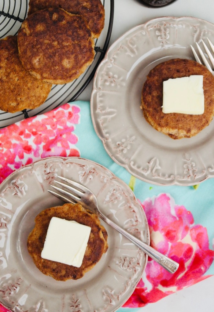 Overhead view of pancakes on tan plates ready to be eaten.