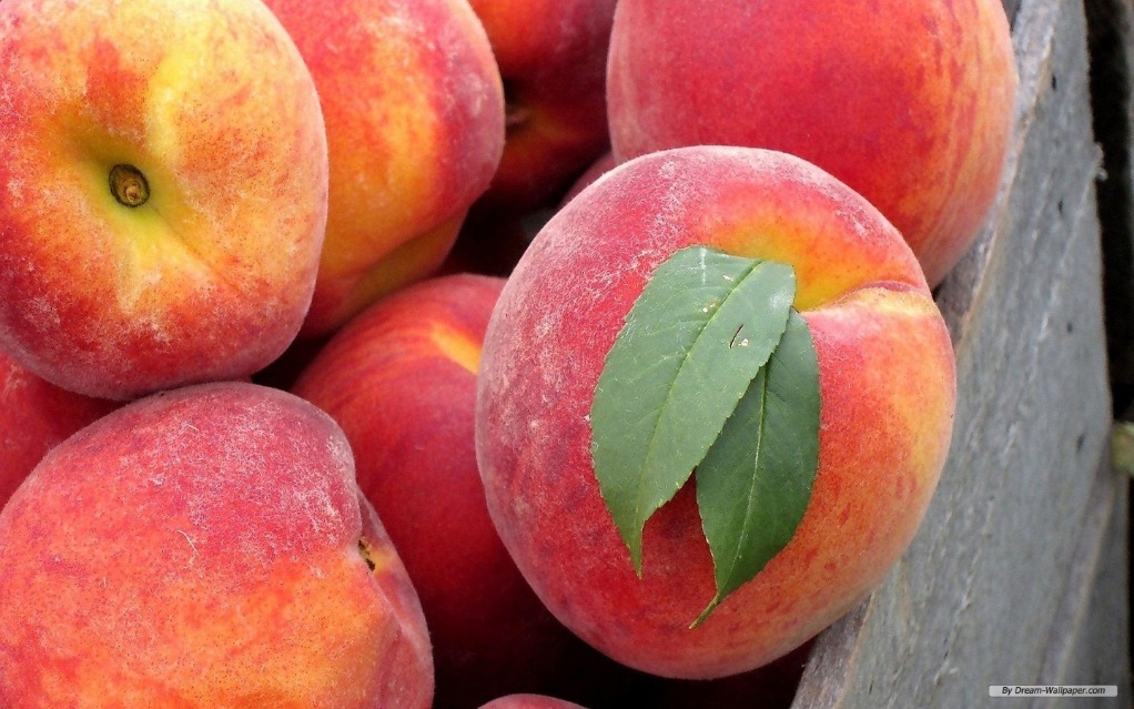 Photo of fresh peaches in a wooden crate