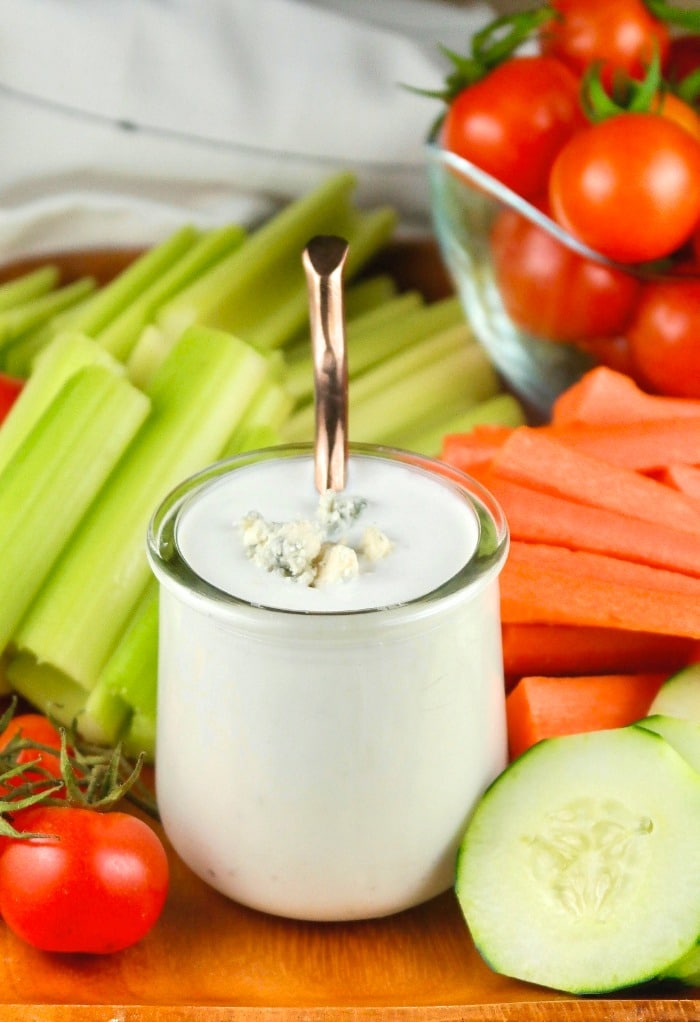 Small clear jar filled with blue cheese sauce for dipping vegetables. 
