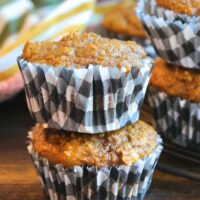 Two pumpkin protein muffins on top of the other in black and white checkered muffin liner.