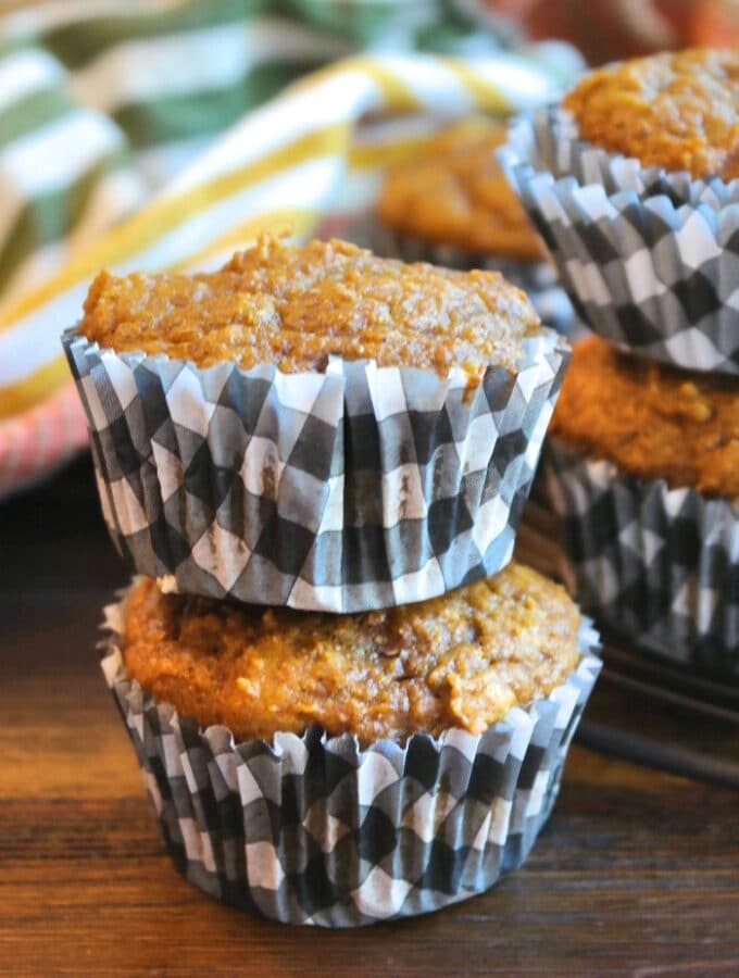 Two pumpkin protein muffins on top of the other in black and white checkered muffin liner.