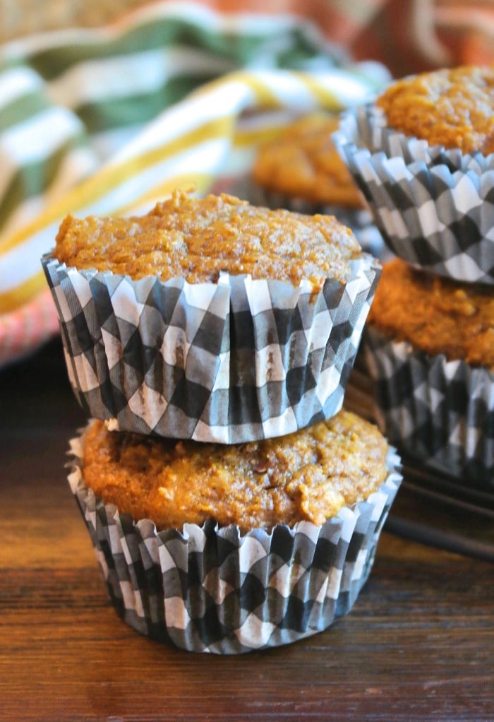 Two pumpkin protein muffins on top of the other in black and white checkered muffin liner. 